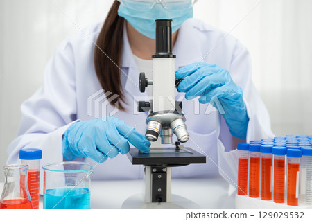Scientist medical professional use microscope for research in science laboratory. 129029532