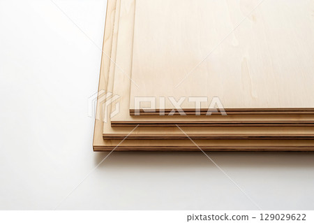 Four plywood sheets are stacked, creating a visually appealing staircase effect against a clean white backdrop 129029622