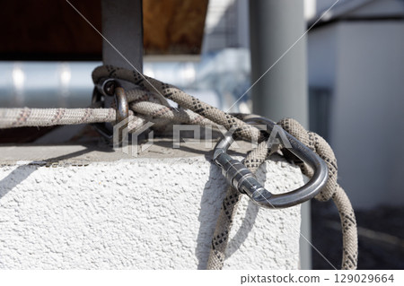 A Close-Up of Steel Lock and Rope Secured to a Wall with Attention to Detail in the Construction and Texture of Material 129029664