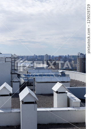 A Panoramic View of Urban Rooftops Surrounded by Modern High-Rise Buildings and a Beautiful Cloudy Sky A Panoramic View of Urban Rooftops Surrounded by Modern High-Rise Buildings and a Beautiful Cloudy Sky 129029729