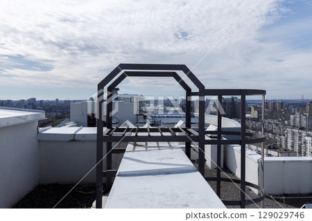 A Stunning Rooftop View: An Intriguing Perspective of an Urban Landscape Showcasing a Unique Metal Structure Against a Beautiful Sky A Stunning Rooftop View: An Intriguing Perspective of an Urban Landscape Showcasing a Unique Metal Structure Against a Beautiful Sky 129029746