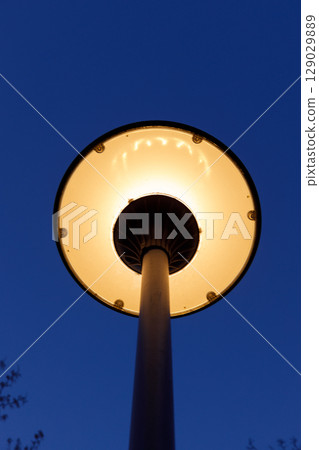 Illuminated Street Lamp Against a Deep Blue Sky A Scenic Evening View of Urban Lighting in Twilight 129029889