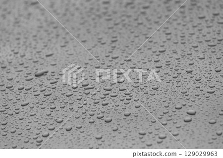 Close-Up View of Raindrops on a Surface, Showcasing the Beauty of Nature s Elements in Monochrome Style, Evoking Feelings of Calmness and Reflection on a Rainy Day 129029963