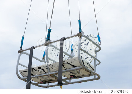 A Unique and Captivating View of an Aerial Chairlift Gondola Suspended in the Air with a Dramatic Sky Backdrop Perfect for Ski Resorts and Adventure Enthusiasts A Unique and Captivating View of an Aerial Chairlift Gondola Suspended in the Air with a Dramatic Sky Backdrop Perfect for Ski Resorts and Adventure Enthusiasts 129029992