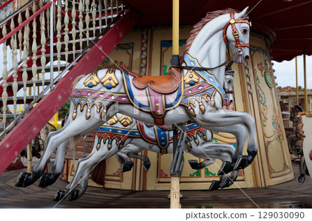 Colorful Carousel Horses on an Amusement Park Ride Adding Joyful Charm to the Enchanting Atmosphere of a Vibrant Fairground Scene for Children and Families to Enjoy Colorful Carousel Horses on an Amusement Park Ride Adding Joyful Charm to the Enchanting Atmosphere of a Vibrant Fairground Scene for Children and Families to Enjoy 129030090