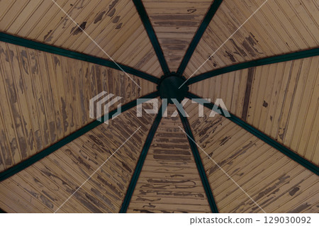 A Unique Perspective of a Vintage Gazebo Roof Showcasing Intricate Wooden Patterns and Decorations with Green Trim Enhancing its Aesthetic Appeal 129030092