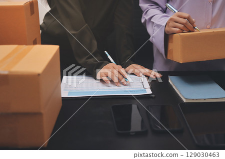 Portrait of Starting small businesses SME owners, two Asian woman check online orders Selling products working with boxs freelance work at home office, sme business online small medium enterprise Portrait of Starting small businesses SME owners, two Asian woman check online orders Selling products working with boxs freelance work at home office, sme business online small medium enterprise 129030463