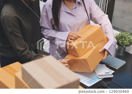 Portrait of Starting small businesses SME owners, two Asian woman check online orders Selling products working with boxs freelance work at home office, sme business online small medium enterprise Portrait of Starting small businesses SME owners, two Asian woman check online orders Selling products working with boxs freelance work at home office, sme business online small medium enterprise 129030469