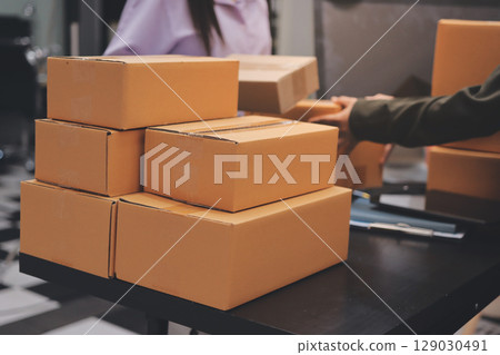 Portrait of Starting small businesses SME owners, two Asian woman check online orders Selling products working with boxs freelance work at home office, sme business online small medium enterprise Portrait of Starting small businesses SME owners, two Asian woman check online orders Selling products working with boxs freelance work at home office, sme business online small medium enterprise 129030491