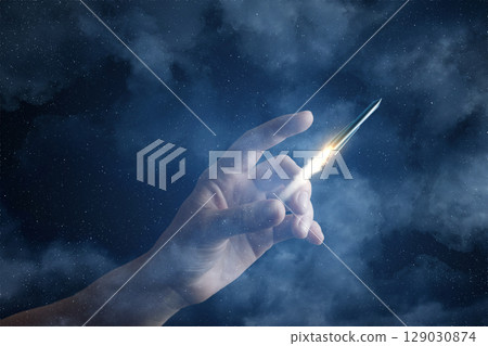 Hand launching a rocket against a starry sky Hand launching a rocket against a starry sky 129030874