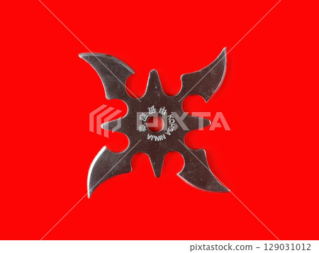 Throwing star shuriken, traditional Japanese ninja bladed weapon on red background. Kohga Ninja inscription. Throwing star shuriken, traditional Japanese ninja bladed weapon on red background. Kohga Ninja inscription. 129031012