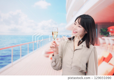Young woman drinking sparkling wine on the deck of a cruise ship Young woman drinking sparkling wine on the deck of a cruise ship 129031090