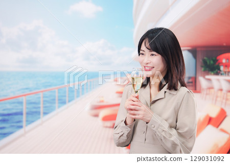 年輕女子在遊輪甲板上喝氣泡酒 年輕女子在遊輪甲板上喝氣泡酒 129031092