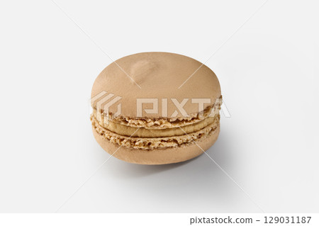 Single coffee macaron resting on white background 129031187