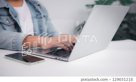 Student hands typing on laptop with virtual learning icons overlay, online education, e-learning, digital study concept. 129031218
