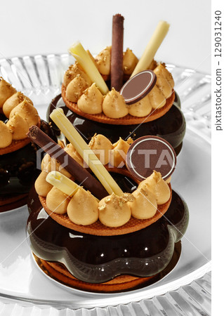 Delicious chocolate cakes decorated with gold and caramel cream filling glass serving dish Delicious chocolate cakes decorated with gold and caramel cream filling glass serving dish 129031240