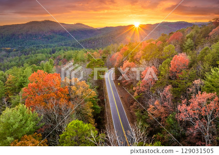 Winding forest road in Tennessee Appalachians during fall. Car traveling through mountain woods under glowing autumn leaves 129031505