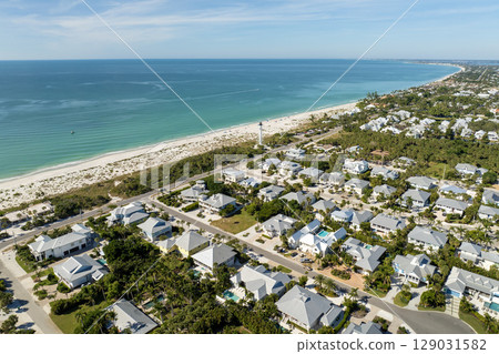 Wealthy neighborhood in small town Boca Grande, Florida with expensive waterfront houses between green palm trees. Development of US premium housing 129031582