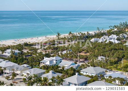 Wealthy neighborhood in small town Boca Grande, Florida with expensive waterfront houses between green palm trees. Development of US premium housing 129031583
