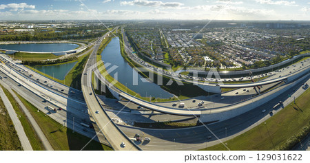 USA transportation infrastructure concept. View from above of american big freeway intersection in Miami, Florida with fast moving cars and trucks 129031622