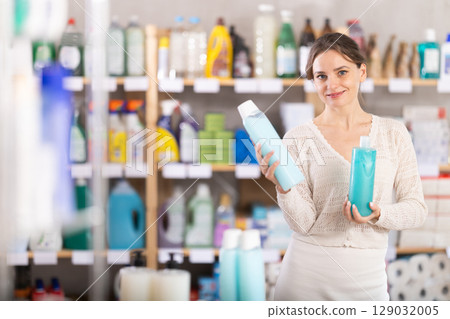 Woman purchases household chemicals in store and chooses shampoo or shower gel Woman purchases household chemicals in store and chooses shampoo or shower gel 129032005