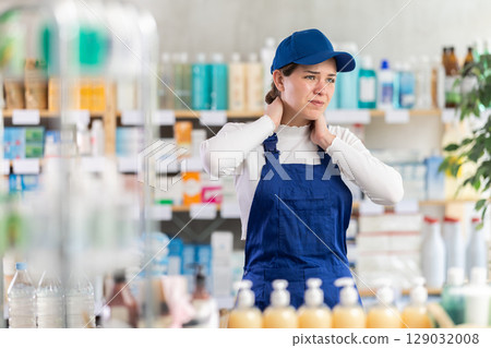 Young woman worker with neck pain at pharmacy 129032008