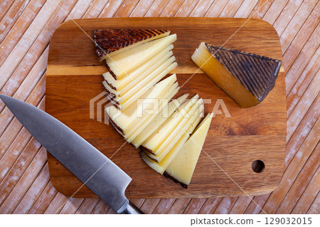 Slices of semi-hard spanish sheep cheese on desk Slices of semi-hard spanish sheep cheese on desk 129032015