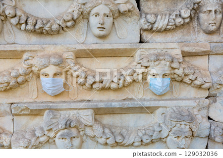 Relief sculptures with wearing medical masks in ancient city of Aphrodisias. Turkey 129032036