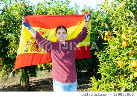 Girl football fan waving Spanish flag during tangerines harvest 129032068
