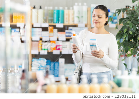 Female customer examining beauty products in drugstore 129032111