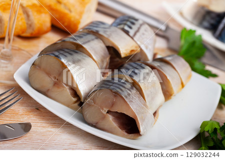 Lightly salted mackerel cut into pieces with parsley on table Lightly salted mackerel cut into pieces with parsley on table 129032244