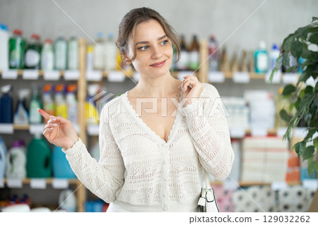 Woman wanders around store, looking at display cases Woman wanders around store, looking at display cases 129032262