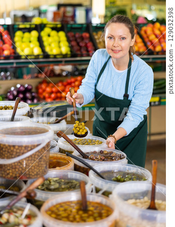 woman seller offers to buy olives 129032398