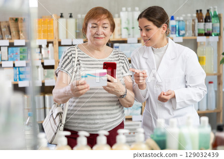 Woman buyer scans pills qr code with woman pharmacist Woman buyer scans pills qr code with woman pharmacist 129032439