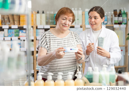 Woman choosing ointment with help from pharmacist 129032440