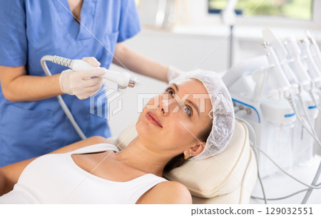 Young woman undergoing facial procedure using atomized cosmetic nutrients 129032551