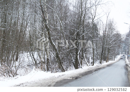 Trees grow along the road in winter. Winter Road. Trees grow along the road in winter. Winter Road. 129032582