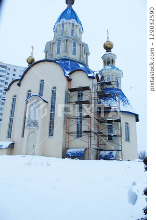 Yellow-blue church in the snow vertical photo. Winter landscape with church. 129032590