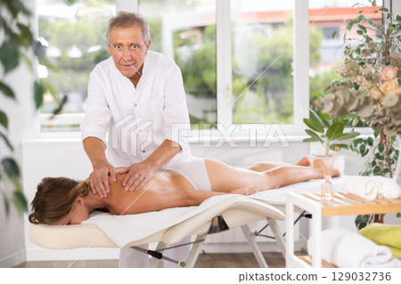 male masseur giving massage to female patient 129032736