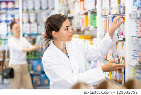 Pharmacy employee puts new healing body cosmetics on shelves 129032752