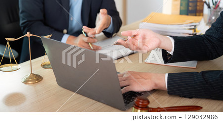 Legal Meeting. Lawyer and client reviewing case documents at desk. Legal Meeting. Lawyer and client reviewing case documents at desk. 129032986