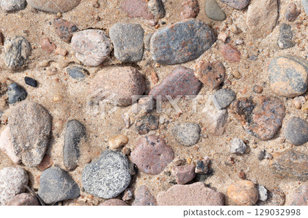 Close-Up of Multicolored Pebbles Mixed with Beach Sand Texture 129032998