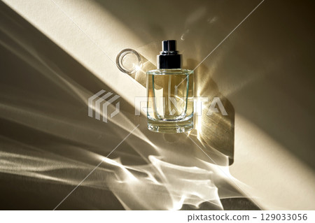 Perfume in the rays of bright sun with beautiful highlights. 129033056