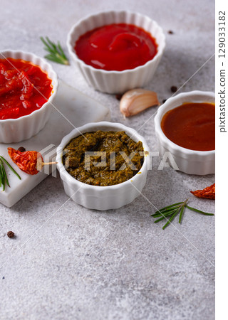 Set of different sauces. Ketchup, mustard, pesto 129033182