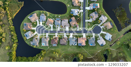 Upscale suburban homes with large backyards and green grassy lawns. Private residential houses in rural suburban sprawl area in Sarasota, Florida Upscale suburban homes with large backyards and green grassy lawns. Private residential houses in rural suburban sprawl area in Sarasota, Florida 129033207