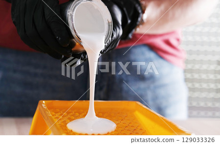Repairman Pouring White Paint Into Paint Tray 129033326