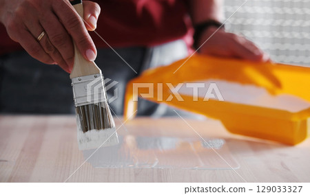 Paintbrush With White Paint Painting Wooden Surface 129033327