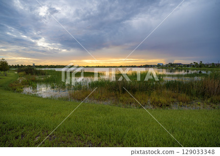 Sunset landscape in Wellen park in North Port, Florida. Beautiful lake nature in evening Sunset landscape in Wellen park in North Port, Florida. Beautiful lake nature in evening 129033348
