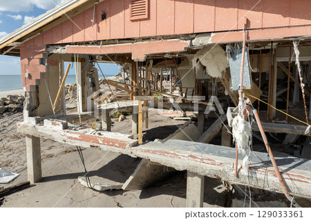 Storm surge severe damage to residential houses on ocean shore after hurricane landfall. Natural disaster consequences in Florida Storm surge severe damage to residential houses on ocean shore after hurricane landfall. Natural disaster consequences in Florida 129033361