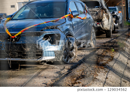 Wrecked and burned cars in scrapyard after crashes, showing severe damage and destruction Wrecked and burned cars in scrapyard after crashes, showing severe damage and destruction 129034562